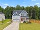 Beautiful two-story home with attached garage, patriotic flag, and expansive manicured lawn at 70 Noble Heart Pl, Fuquay Varina, NC 27526