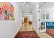 Open foyer with wood floors, chandelier, colorful art, and a glimpse into the living room at 70 Noble Heart Pl, Fuquay Varina, NC 27526