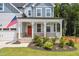 Beautiful home featuring a welcoming front porch, red front door, and manicured lawn at 70 Noble Heart Pl, Fuquay Varina, NC 27526