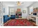 Bright home office with blue sofa, white desk, decorative rug, and ample natural light at 70 Noble Heart Pl, Fuquay Varina, NC 27526