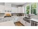 Modern kitchen with white cabinetry, stainless steel appliances, and a large farmhouse style sink at 70 Noble Heart Pl, Fuquay Varina, NC 27526