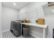 Well-organized laundry room with modern appliances, patterned flooring, and ample storage space at 70 Noble Heart Pl, Fuquay Varina, NC 27526