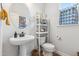 Charming powder room with a pedestal sink, round mirror and stylish decor at 70 Noble Heart Pl, Fuquay Varina, NC 27526