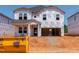 New construction home featuring a two-car garage and covered porch, with Tyvek wrap and construction materials surrounding at 756 Deschutes Dr, Garner, NC 27529