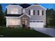 Charming two-story home featuring gray siding, stone accents, a two-car garage and professionally landscaped front yard at 756 Deschutes Dr, Garner, NC 27529
