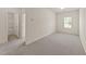 A bedroom with neutral carpet, a window for natural light, and an open door to the bathroom at 908 Adelphia Rd, Fuquay Varina, NC 27526