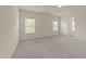 Bright bedroom with a neutral carpet, multiple windows, and a view into the hallway at 908 Adelphia Rd, Fuquay Varina, NC 27526