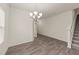 Dining area with a modern chandelier and staircase view, complemented by wood-look flooring at 908 Adelphia Rd, Fuquay Varina, NC 27526