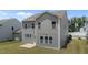 Backyard view of two-story house featuring an open yard with lush green lawn and concrete patio at 908 Adelphia Rd, Fuquay Varina, NC 27526