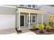 Close up of the front entrance featuring a black door, white columns, and manicured landscaping at 908 Adelphia Rd, Fuquay Varina, NC 27526