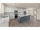A modern kitchen with white cabinets, stainless steel appliances, and a large center island with a marble countertop at 908 Adelphia Rd, Fuquay Varina, NC 27526