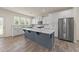 A modern kitchen with white cabinets, stainless steel appliances, and a large center island with a marble countertop at 908 Adelphia Rd, Fuquay Varina, NC 27526