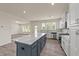 A modern kitchen with white cabinets, stainless steel appliances, and a large center island with a marble countertop at 908 Adelphia Rd, Fuquay Varina, NC 27526