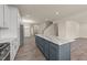 A modern kitchen with white cabinets, stainless steel appliances, and a large center island with a marble countertop at 908 Adelphia Rd, Fuquay Varina, NC 27526