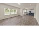Spacious living area with wood-look flooring, bright windows, and adjacent open kitchen at 908 Adelphia Rd, Fuquay Varina, NC 27526