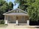 Charming, cozy single-story home with inviting porch, surrounded by mature trees at 911 Holloway St, Durham, NC 27701