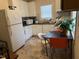 Kitchen with linoleum flooring, white cabinets, a table with chairs and a window at 911 Holloway St, Durham, NC 27701