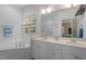 Bathroom with a soaking tub under a window, a double sink, and tiled floors at 92 Summer Dawn, Pittsboro, NC 27312