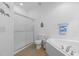 Bright, white bathroom with a glass shower, toilet, and corner tub with tiled walls and flooring at 92 Summer Dawn, Pittsboro, NC 27312