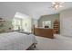 Large upstairs bedroom with a bed, seating area, desk, bookshelf, and multiple windows for natural light at 92 Summer Dawn, Pittsboro, NC 27312