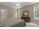 Neutral bedroom features bright natural light, tan walls, and a charming wood dresser with a mirror at 92 Summer Dawn, Pittsboro, NC 27312