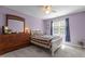 Comfortable bedroom with white bed, ceiling fan, light purple walls, and window at 92 Summer Dawn, Pittsboro, NC 27312