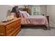 Charming bedroom with wood dresser and nightstand, natural light and floral bedding at 92 Summer Dawn, Pittsboro, NC 27312