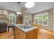 Well-lit kitchen with wood floors, granite counters, stainless steel appliances, and views of the backyard at 92 Summer Dawn, Pittsboro, NC 27312