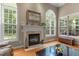 Cozy living room features a fireplace, large windows, and wood floors at 92 Summer Dawn, Pittsboro, NC 27312