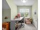Well-lit home office features a large window, desk, office chair, and neutral green walls and carpeting at 92 Summer Dawn, Pittsboro, NC 27312