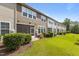 A grassy backyard featuring a screen door entrance, shrubbery, and landscaping at 9302 Nellman Ln, Raleigh, NC 27617