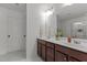 Elegant bathroom with a dual sink vanity, wood cabinets, ample counter space, and a large mirror at 9302 Nellman Ln, Raleigh, NC 27617