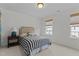 Comfortable bedroom with a striped bedspread, bedside table, and natural light streaming in from windows at 9302 Nellman Ln, Raleigh, NC 27617