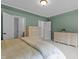 Light-filled bedroom with neutral walls and carpet complemented by a large dresser for ample storage space at 9302 Nellman Ln, Raleigh, NC 27617