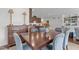 Dining room with wood table, blue upholstered chairs, and views of the open kitchen and living spaces at 9302 Nellman Ln, Raleigh, NC 27617