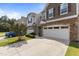 Three townhomes feature stone accents, neutral siding, white garage doors, and well-maintained landscaping at 9302 Nellman Ln, Raleigh, NC 27617