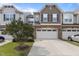 An exterior view of townhomes featuring stone accents, a driveway, and well maintained landscaping at 9302 Nellman Ln, Raleigh, NC 27617