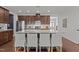 Kitchen island features seating and stainless appliances in this space with brown wood cabinets and hardwood floors at 9302 Nellman Ln, Raleigh, NC 27617
