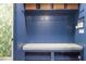Mudroom with blue cabinets, cushioned bench seating, coat hooks, and overhead basket storage at 9302 Nellman Ln, Raleigh, NC 27617