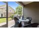 Covered screened patio with table and wicker chairs offers a relaxing outdoor space with view of the neighborhood at 9302 Nellman Ln, Raleigh, NC 27617