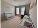 Bright Bedroom featuring a white crib, changing table, and comfortable armchair, creating a cozy space at 1005 Lathrop Ln, Apex, NC 27523