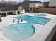Outdoor community pool with ' water feature, nearby houses, and sunbathing area at 1005 Lathrop Ln, Apex, NC 27523