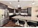 Modern kitchen with dark cabinets, granite countertops, stainless steel appliances, and a large island with bar seating at 1005 Lathrop Ln, Apex, NC 27523