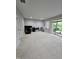 Spacious living room featuring neutral walls, carpet, a sliding glass door leading to the outdoors, and comfortable seating at 1005 Lathrop Ln, Apex, NC 27523