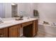Well-lit bathroom with double sinks, oak cabinets, soaking tub, and tile floors at 101 Lake Tillery Dr, Cary, NC 27519