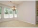 Bright dining room with decorative chandelier and bay window overlooking greenery at 101 Lake Tillery Dr, Cary, NC 27519
