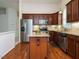 Modern kitchen with stainless steel appliances, granite counters, dark wood cabinets, and an island for meal prep at 101 Lake Tillery Dr, Cary, NC 27519