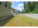 Spacious backyard featuring a well-maintained lawn and a secure white fence for privacy at 1013 Poppy Fields Ln, Wake Forest, NC 27587