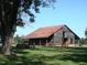 Rustic barn with a weathered roof, surrounded by open fields and a mature tree at 1013 Poppy Fields Ln, Wake Forest, NC 27587