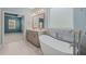 Luxurious primary bathroom featuring a soaking tub and tiled backsplash, offering a spa-like retreat at 1013 Poppy Fields Ln, Wake Forest, NC 27587